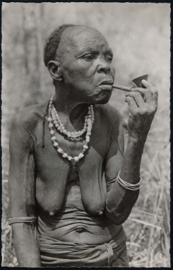 vintagecongo:Vieille Femme Mushi (Kivu), Congo Belge. Leonard A. Lauder Archive Postcard Archive—Gift of Leonard A. Lauder [Old Mushi (Shi) woman from Kivu smoking]