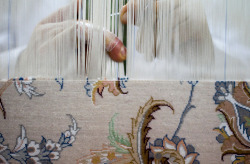 sufiness:  A weaver works on a carpet at a carpet workshop in