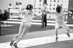 modernfencing:  [ID: an epee fencer fleching at her opponent.]