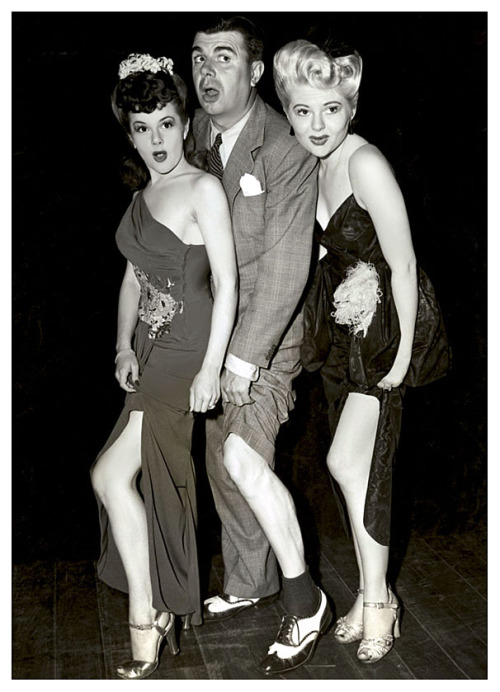 Showgirls Odessa Lauren (Left) and Doris Duane (Right) sandwich comedian: Ken Murray, in a publicity photo for his popular “Blackouts of Ken Murray” Burlesque show..