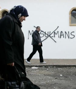 na3saan:  fnhfal:  Muslim residents walk past slurs painted on