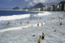 unrar:  People play in surf along beach lined with apartment