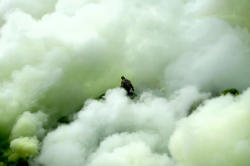 aquaticwonder:  An Indonesian sulfur miner collects sulfur surrounded