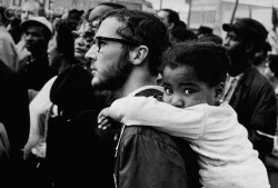  A white man carries a black girl on his shoulders during a march