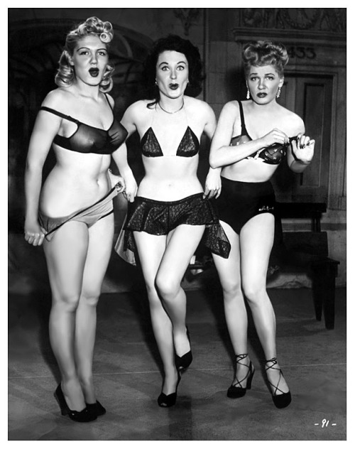      COSTUME ADJUSTMENTS.. Jennie Lee (at Left) is featured with good friends: Pat Flannery (middle) and Doreen Gray, in a publicity photo for the 1951 Burlesque film: “DING-DONG! A NIGHT in the MOULIN ROUGE”.. It was a documentary-style recor