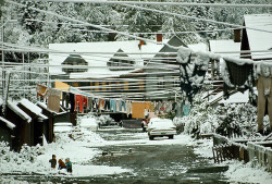 natgeofound:  Snow hides begrimed houses, laundry, and slag in