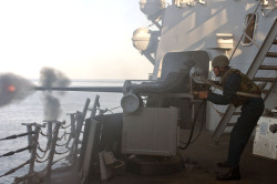 nemoi:  A Sailor fires a 25mm gun at sea. (via Official U.S.