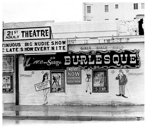 Vintage candid photo from September of 1969 features a rainy afternoon at the ‘21st ADULT Theatre’; located on Collins Avenue (at 21st Street) in Miami Beach, Florida.. Despite it’s rather seamy appearance, small signs still encouraged husbands