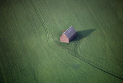 unrar:Aerial view of a barn in the middle of an lush green field,