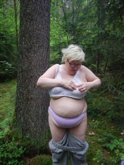 This chubby old granny is undressing in the woods much to our