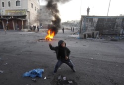 flewly:   A Palestinian child throws stones toward Israeli border