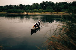 aliirq:    Iraqi school girls paddle a small wooden boat across
