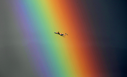 ps1:An airplane passes in front of a rainbow above the Mediterranean