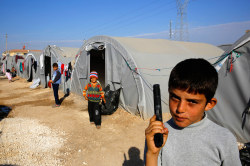 unrar:A young Kurdish refugee from Kobani holds a toy pistol