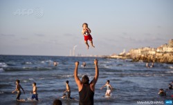 afp-photo:  GAZA CITY : A Palestinian man plays with his baby
