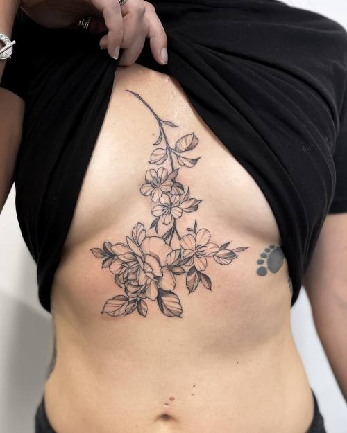 allthepiercingsandbodymods:Sternum flower tattoos by campohltattoos.