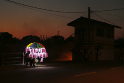 fotojournalismus:  A candy floss vendor awaits customers by a