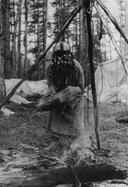 eurasian-shamanism:  Evenk shamaness heating her drum over fire.