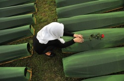 politics-war:A Bosnian Muslim woman mourns over the casket of