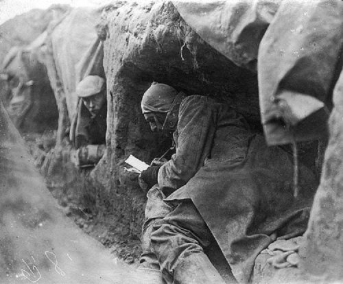 A soldier in a trench during the First World War writes letters