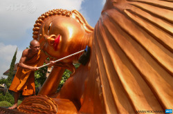 afp-photo:  INDONESIA, Malang : A monk cleans a huge reclining