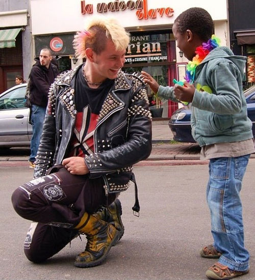Tough enough (a punk rocker kneels down to let a young boy touch the spikes on his jacket … *awesome*)