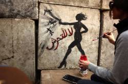 mideastcuts:An Egyptian activist draws graffiti depicting a woman