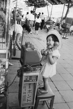 historicaltimes:  A little girl having fun pretending to talk