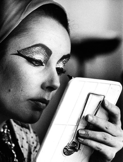 the60sbazaar:  Elizabeth Taylor applies her makeup on the set