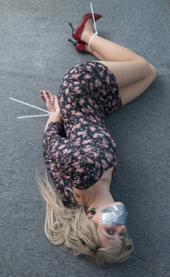 allthingsfetish:  Blonde babe lying on the floor tape gagged