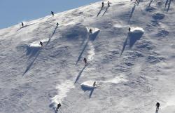unrar:Tourists go down a hill in the Alpine skiing resort of