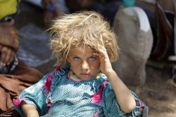 A girl from the minority Yazidi sect rests at the Iraqi-Syrian