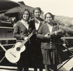 mudwerks:Three young women with a guitar and a ukelele, stand