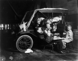 An elderly couple enjoy a meal outside of their automobile home,