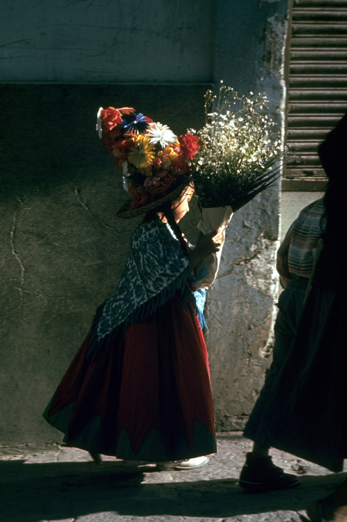 vintageeveryday:A child carrying bouquet on way to fiesta in