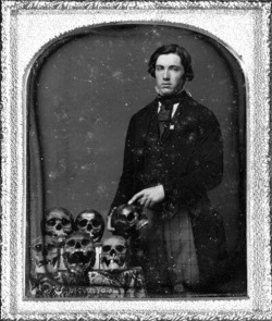 A young man with his collection of human skulls.