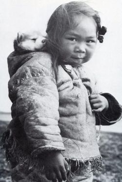 darksilenceinsuburbia:An Inuk girl with her husky puppy in the