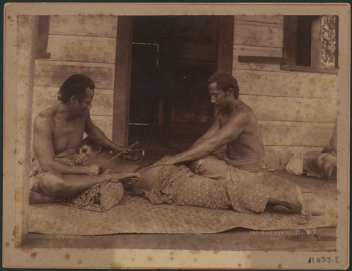 By Thomas Andrew, c. 1890, via Auckland Museum:  Tattooing, Samoa: Tufuga ta tatau making a tatau on a man’s back.