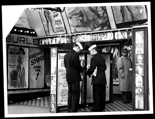 Press photo dated from the mid-50’s features an unidentified Burlesque theatre on South Wabash Avenue in Chicago.. A pair of sailors check their wallets to see if they have enough cash to catch (yet) another viewing of Irving Klaw’s 1954 film: