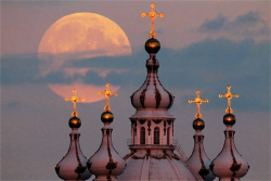  The Harvest Moon is seen rising in the sky above the domes of