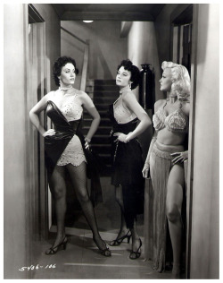 A publicity still from the 1954 noir: “THE HUMAN JUNGLE”, features actress Jan Sterling (at Right) appearing alongside actress twins Sonia and Sandra Warner.. All three were tutored by Burlesque dancer Libby Jones in preparation for their roles as