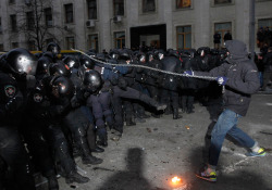 politics-war:  A man swings a chain as protesters try to break