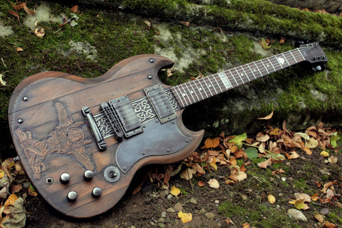 glorifiedguitars:  The Norse SG, featuring carvings of Odin with his two ravens Huginn and Muninn and his two wolves Geri and Freki.This beautiful piece of art was created by the talents at Hutchinson Guitar Concepts. 