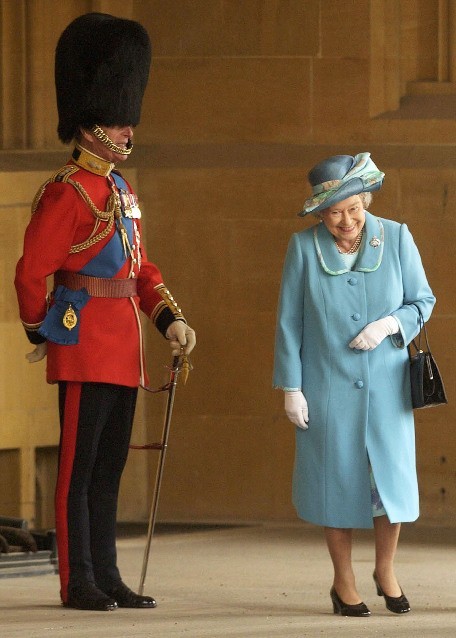 Jocularity (Queen Elizabeth laughs as she walks by her husband Prince Philip, the Duke of Edinburgh, in his full dress uniform)