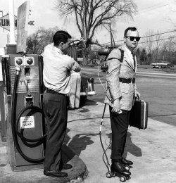 A salesman having his motorized roller skates refueled at a gas