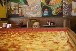  A picture of a baby overwhelmed by pizza 
