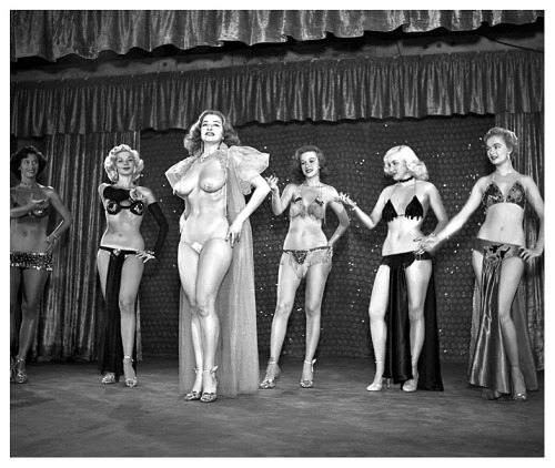   Tempest Storm A publicity still from the 1953 Burlesque film: “A NIGHT IN HOLLYWOOD”, features Ms. Storm at center stage.. Misty Ayres (at Left) and Mae Blondell (at Right), are the 2 blond dancers seen behind her.. The film was shot at