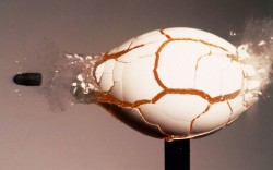 sixpenceee: A raw egg fractures under the force of a 22 cailbre