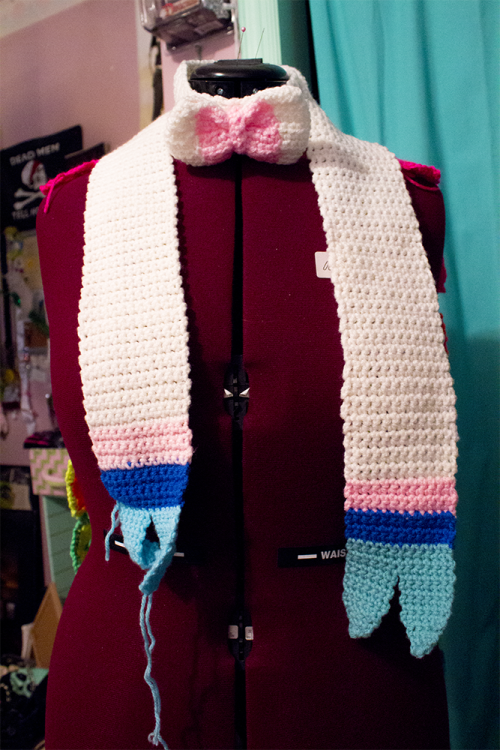 It’s finished! Crocheted Sylveon bowtie scarf! Its all one piece with the tie sewn in the middle. The one on the left was left undone because that was the first attempt; the colors were off and I made the stripes too wide, so that’s going