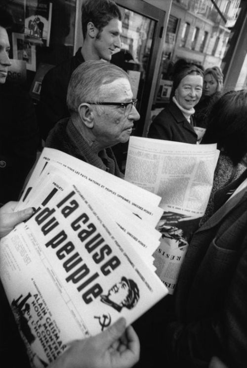 Jean-Paul Sartre avec Simone de Beauvoir (au fond, le regardant